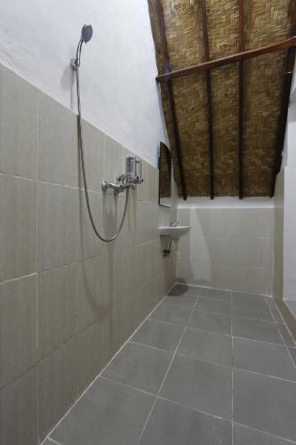 un baño con ducha y lavabo en Jingga Home Penida, en Nusa Penida