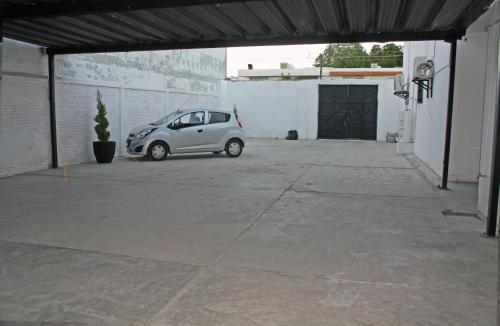 a small car parked in a parking lot at Hotel del Bosque in Torreón
