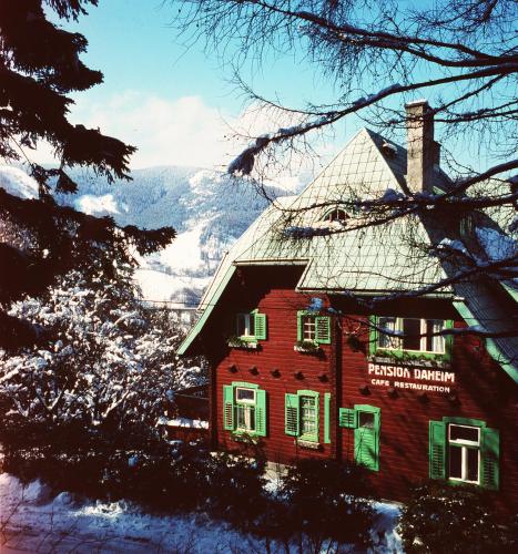 a red house with green shuttered windows and a mountain at Villa Daheim Semmering in Semmering