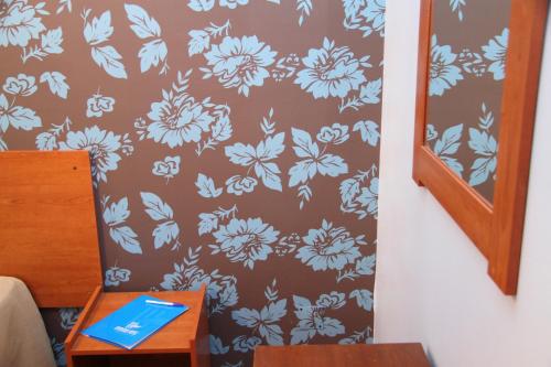 a wall with a blue and white flower wallpaper at Imperio Hotel in Peso da Régua