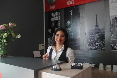 a woman sitting at a counter in a restaurant at Metropolis Suites Ejecutivas in Puebla