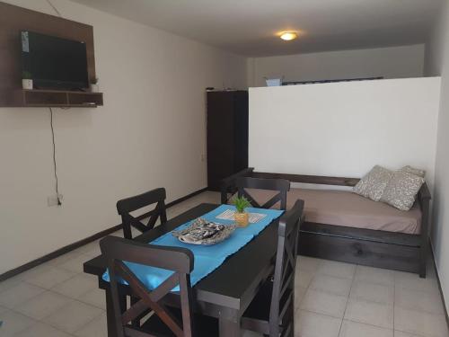a room with a table and chairs and a bed at Departamento Centro in La Rioja