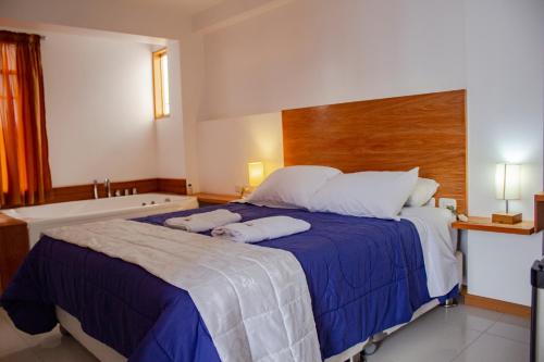 a bedroom with a large bed and a bath tub at Hotel Miramar in Huarmey