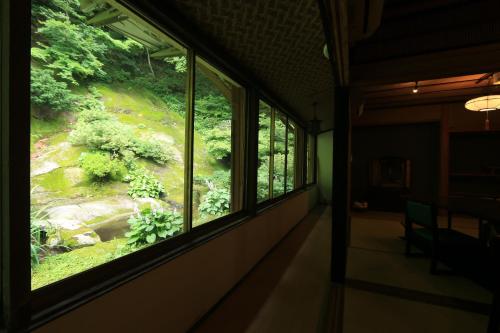 a room with a window with a view of a forest at Shukubo Kansho-in Temple Sanrakuso in Daisen