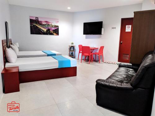 a room with a bed and a couch and a tv at Hotel Turista in Mangangpico