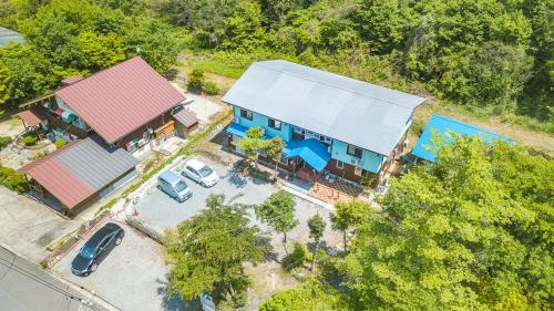 an overhead view of a blue house with a parking lot at Daisen Backpackers in Hoki