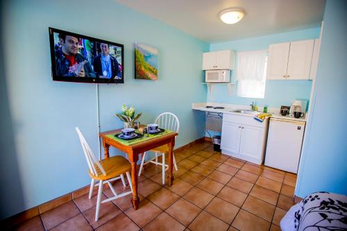 a small kitchen with a table and chairs and a television at Leucadia Beach Inn in Encinitas