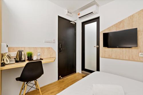 1 dormitorio con puerta negra y silla negra en Rica Hotel Usj, en Subang Jaya