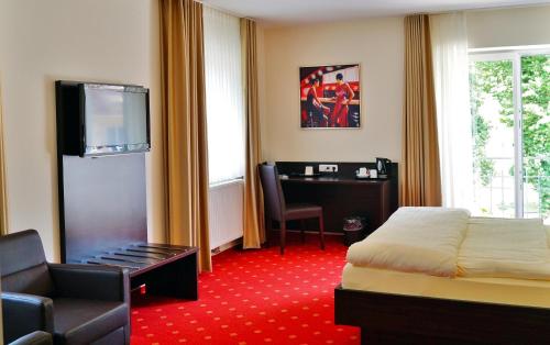 a hotel room with a bed and a desk at Parkhotel Cochem in Cochem