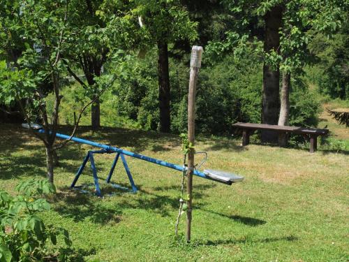 a blue playground in a park with a bench at Apartments Gale in Delnice