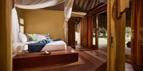 una camera con letto e pavimento in legno di Pearl Beach Resort Gili Asahan a Gili Asahan