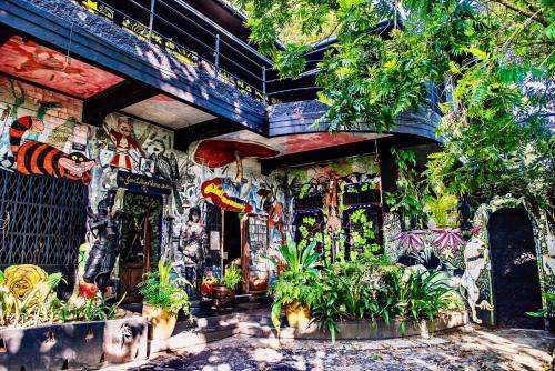 a building with a wall covered in graffiti and plants at HELGASFOLLY Anti Hotel Residence in Kandy