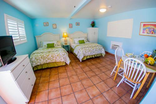 a bedroom with two beds and a flat screen tv at Leucadia Beach Inn in Encinitas