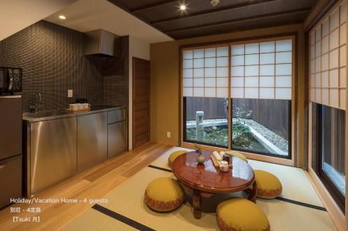 a kitchen with a table and a large window at THE MACHIYA VILLA Sanjo Shirakawa Koji in Kyoto