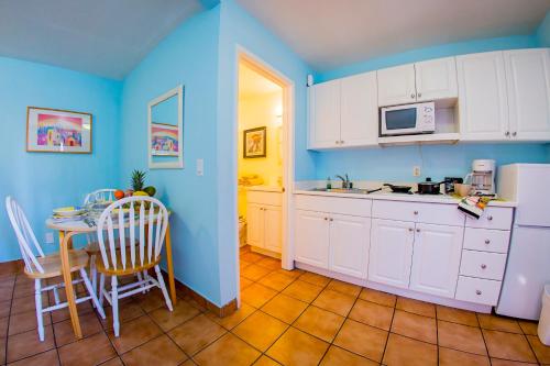 a kitchen with blue walls and a table and chairs at Leucadia Beach Inn in Encinitas