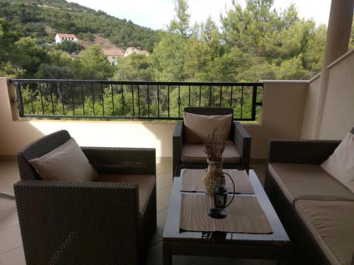 a balcony with two chairs and a table with a view at Apartments Edo in Vis