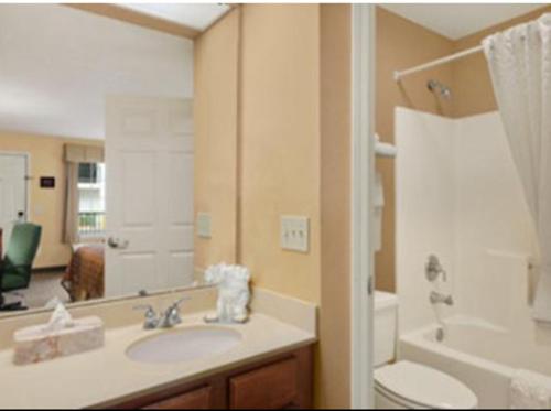 a bathroom with a sink and a toilet and a mirror at Baymont by Wyndham Roanoke Rapids in Roanoke Rapids