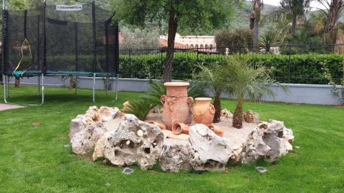 a statue of two vases sitting in the grass at Arcobaleno Apartment in Fondi