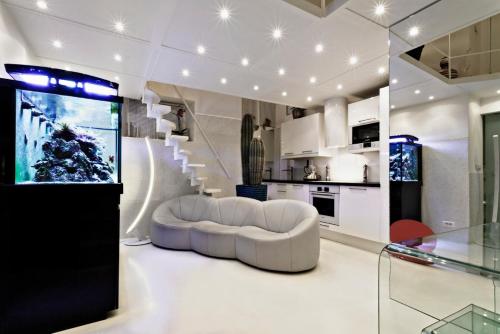 uma sala de estar branca com um sofá branco e escadas em Stylish,luxury duplex Paris city center em Paris