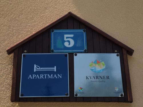 a sign on the side of a building with the number five at Apartments Gale in Delnice
