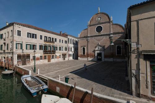 a boat is docked in a canal next to buildings at Appartamenti Palazzo Foscarini . in Venice