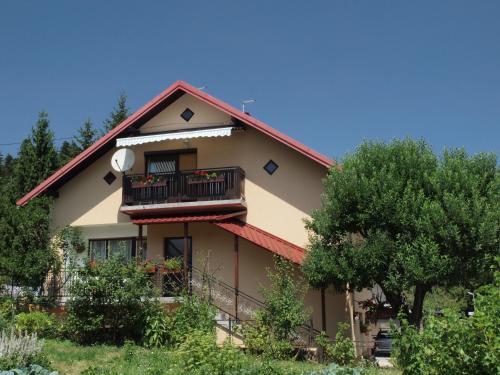 a large house with a balcony and trees at Apartments Gale in Delnice