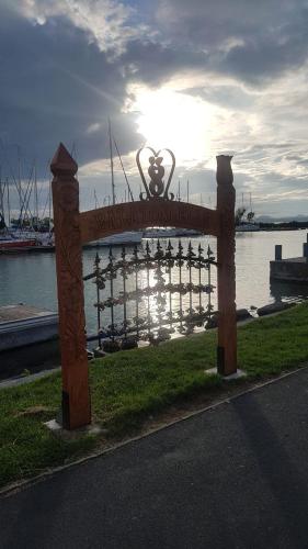 a fence with a statue in front of a body of water at Butique Apartman in Balatonlelle