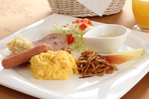 a white plate of food with eggs sausage and a salad at Pension Bloom in Gujo