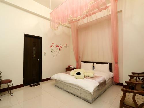 um quarto com um urso de peluche deitado numa cama em Leisure Homestay em Hualien City