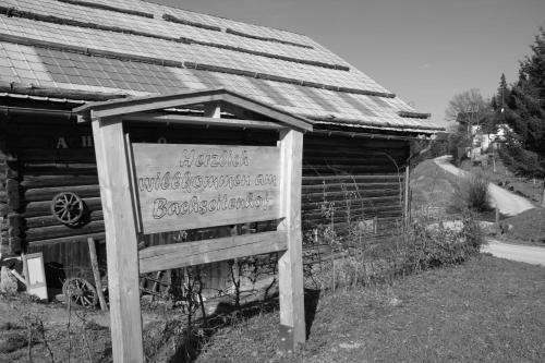 a sign in front of a wooden building at Frühstückspension Bachseitenhof in Radstadt