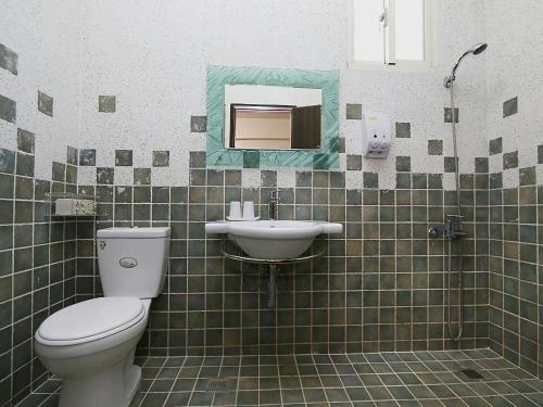 a bathroom with a toilet and a sink at Leisure Homestay in Hualien City