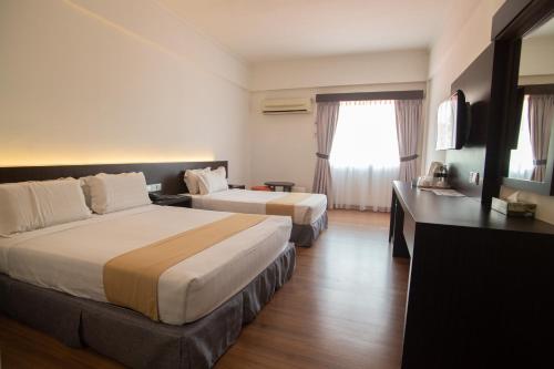 Habitación de hotel con 2 camas y TV en Hotel Seri Malaysia Sungai Petani en Sungai Petani