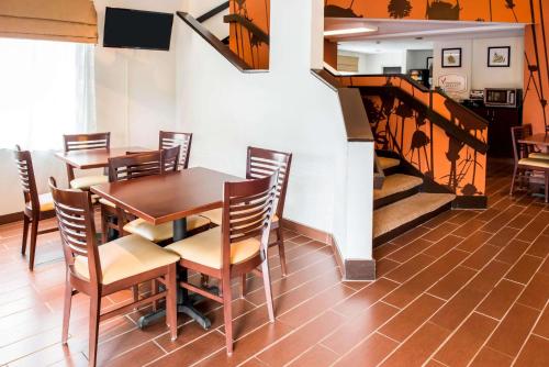uma sala de jantar com uma mesa e cadeiras e uma escadaria em Quality Inn Bridgeport-Clarksburg em Bridgeport