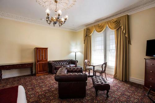 a living room with a couch and chairs and a chandelier at Quality Hotel Bentinck in Portland