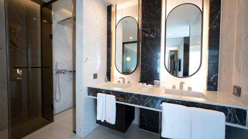 a bathroom with two sinks and two mirrors at Lavalse Hotel in Busan