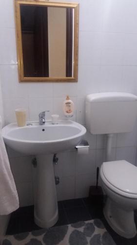 uma casa de banho com um lavatório, um WC e um espelho. em Il Guscio em Santa Teresa di Riva
