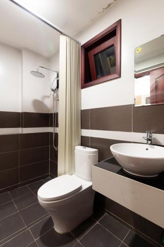 a bathroom with a white toilet and a sink at Riverside Park Eco Resort in Vĩnh Long