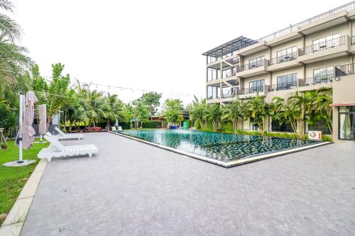 a swimming pool in front of a building at Baan Phing Phu Praew Cha-Am Resort บ้านพิงภูแพรว รีสอร์ท ชะอำ in Cha Am