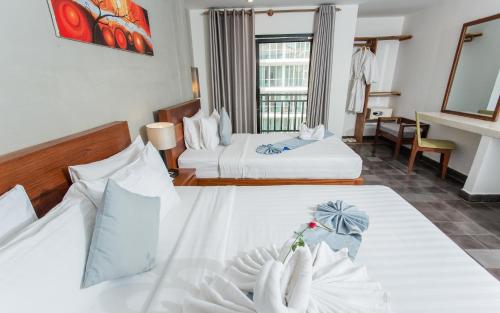 a hotel room with two beds and a balcony at Home Chic Hotel in Phnom Penh