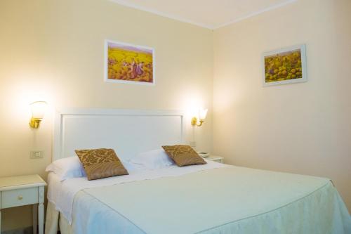 - une chambre avec un lit et deux photos sur le mur dans l'établissement Hotel Seggio, à Vieste