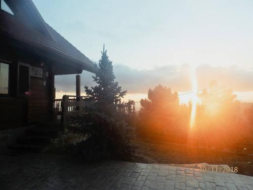 a sunset behind a building with trees in the background at CHALET REGINA in Paradhísion