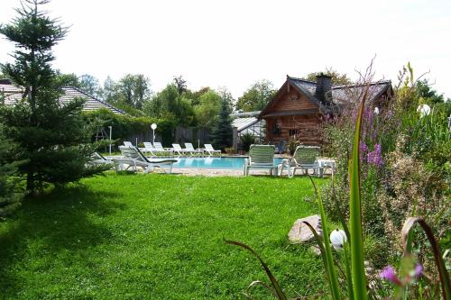 a yard with a pool and chairs and a log cabin at Villa Vier Jahreszeiten in Crimmitschau