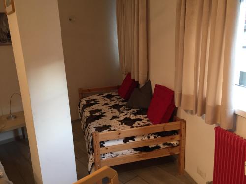 ボルツァーノにあるCasa Laurino In Centro A Bolzanoの小さなベッドルーム(赤い枕のベッド付)
