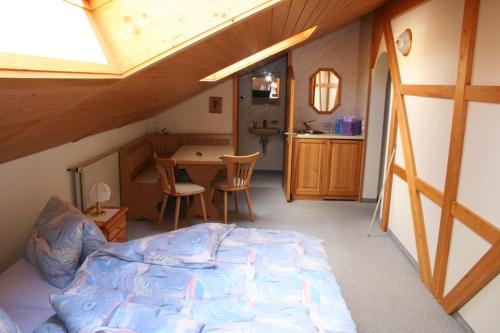 a bedroom with a bed and a table in a room at Hotel Hulfteggpass in Mühlrüti