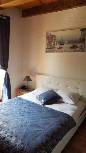 una camera con un letto bianco e un piumone blu di Auberge du Vernay a Charette