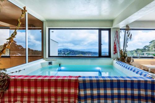 
a bath tub sitting under a window in a swimming pool at Troodos Hotel in Troodos
