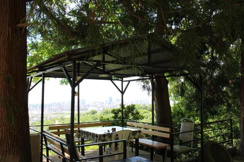 a patio with a table and chairs under a tree at Holiday Home Data in Batumi