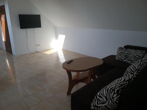 ein Wohnzimmer mit einem Sofa und einem Tisch in der Unterkunft Apartament bocian in Kruklanki