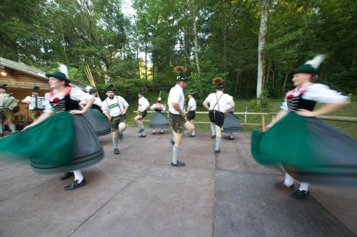 a group of people in green skirts and hats dancing at Hotel Gasthof Post in Nesselwang