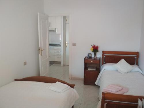 a bedroom with two beds and a door to a bathroom at Apartamento Portosín in Portosin